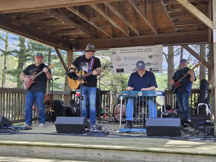 Live band performing on an outdoor stage at the Music and Arts Festival at Fireman's Field in Purcellville, Virginia