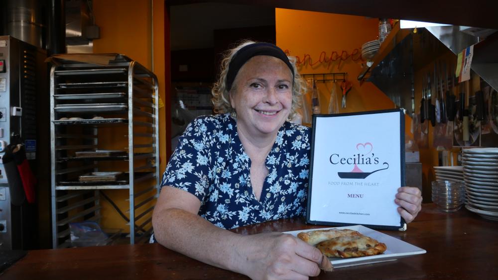 Cecilia Marchesini holds restaurant menu and plate of food