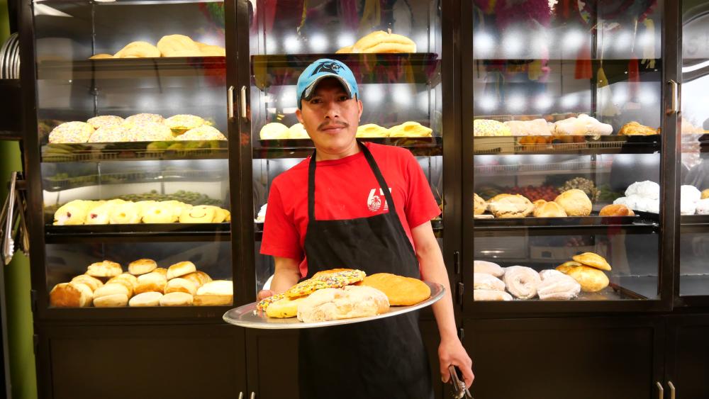 Man hold baked goods from Tienda Los Nenes