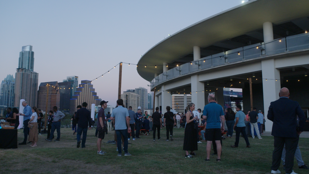 Meeting attendees enjoying a lovely evening on the Long Center lawn with the Austin downtown skyline in the background.