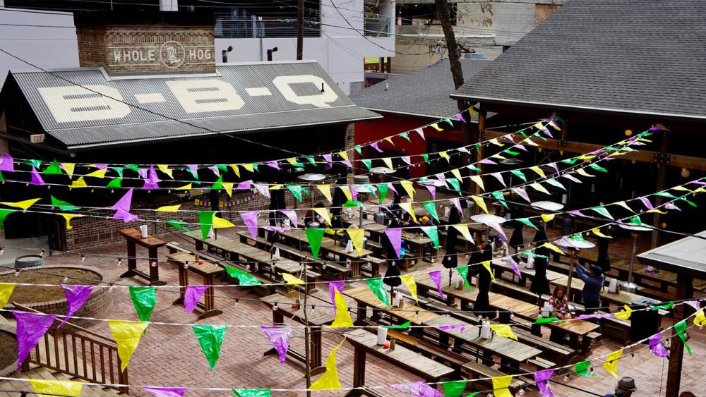Photo from above of the large patio deck at Banger's with purple, yellow and green flags hung over the patio and picnic tables down below.