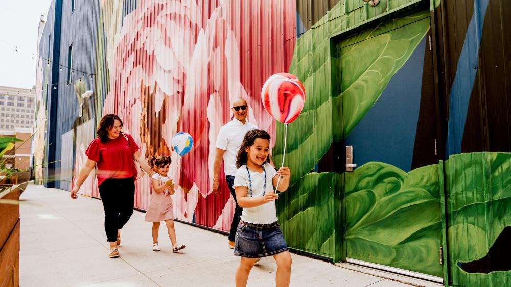 Family walking by Peony mural on The Landing