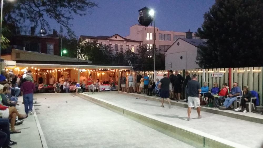 dusk with lights surrounding bocce ball court at pompilios in newport ky