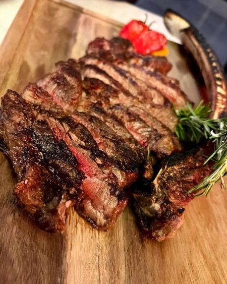 A rare steak sliced and ready to serve on a cutting board