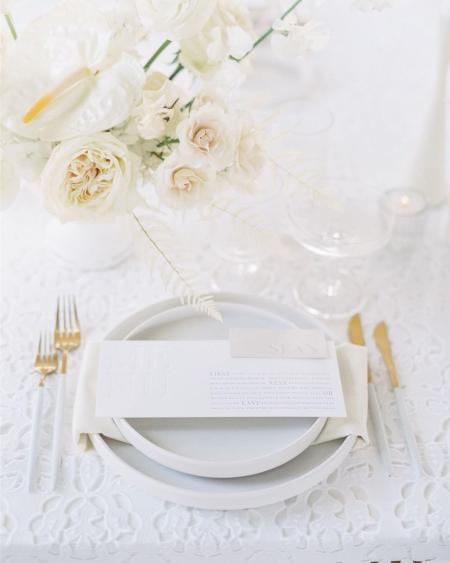 A white place setting at a wedding reception