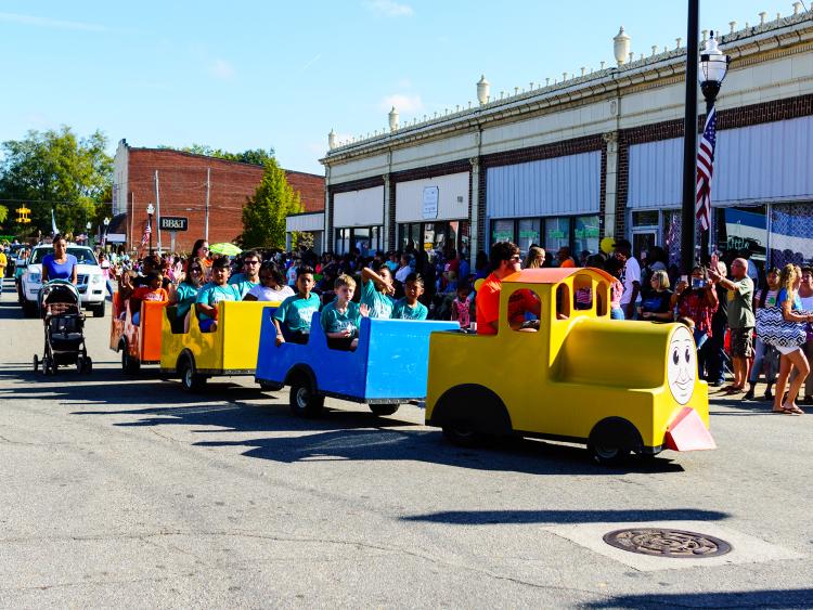 A small train carrying passengers down the streets of Selma, NC, for the annual Selma Railroad Days.