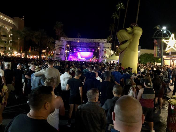 Pride Festival on Palm Canyon with a stage and a crowded street.