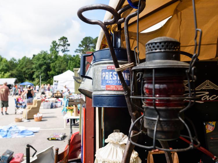 A lantern hangs on a tent booth at a yard sale event