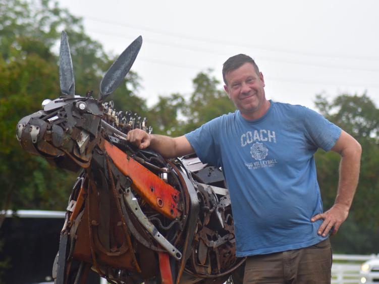 Artist Jonathan Bowling stands with Benson Mule Sculpture