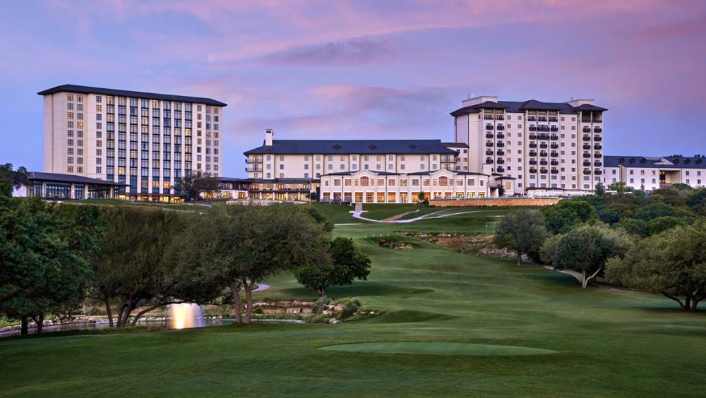 Lush green golf course leading up to Omni Barton Creek Hotel