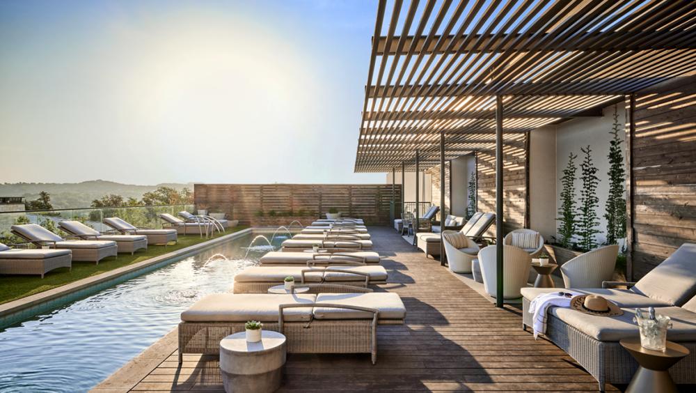 Sunny pool deck lined with outdoor lounge furniture.