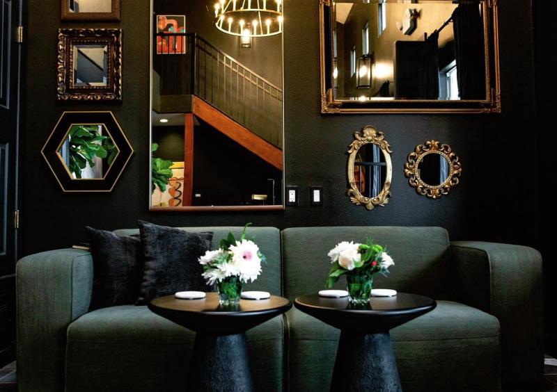 The lobby of El Verde Inn, featuring a couch and a wall of mirrors.
