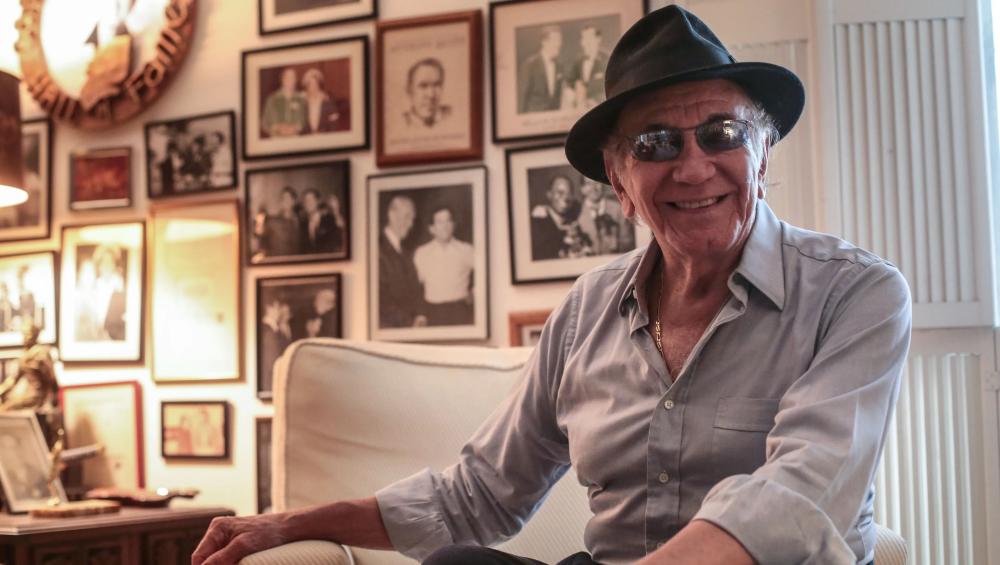 Trini Lopez at home in Palm Springs in his living room with images on the wall.