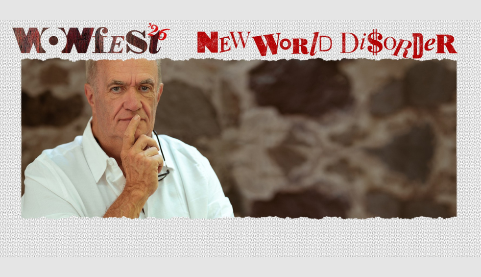 A person wearing a white shirt on a brown background. It says Wowfest26 New World Disorder across the top.
