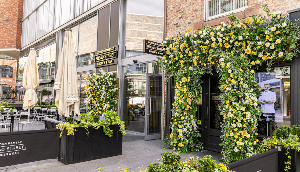Outside of Bread Street kitchen with flowers over the door.