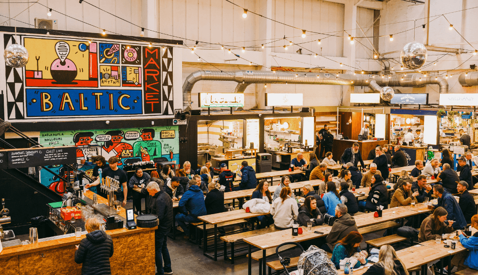 Inside the baltic market with rows of benches and food stalls.