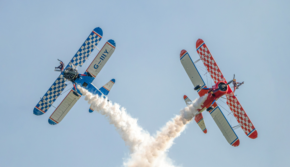 A red and a blue plane flying next to eachother.