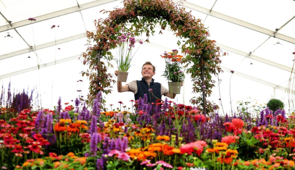 Man holding and standing underneath flowers at the Southport Flower Show