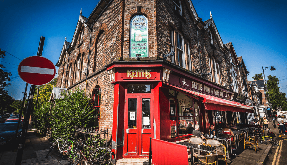 An exterior shot of a cafe with an old Victorian Style shop front painted red