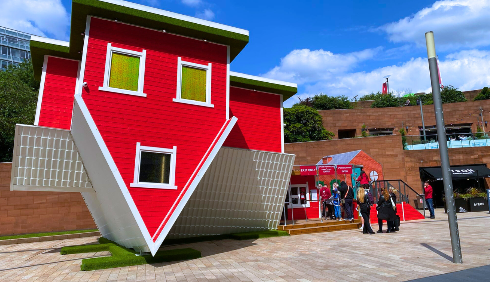 A large red house upside down on its roof.