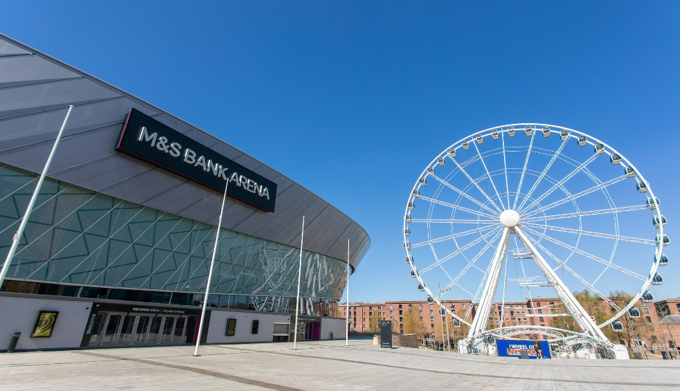 A large viewing wheel next to an arena in Liverpool.