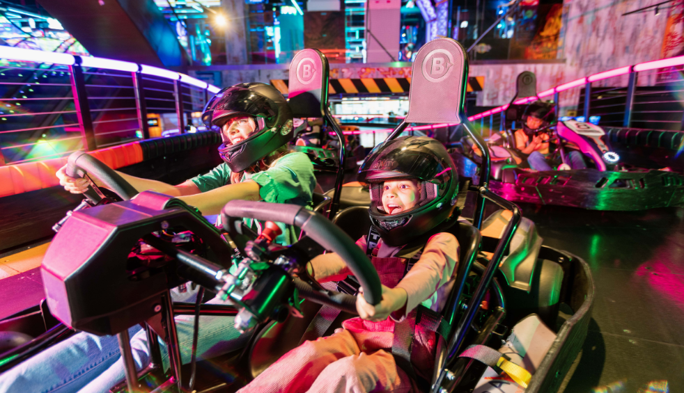 People on a go-karting track in go karts at Gravity Max.