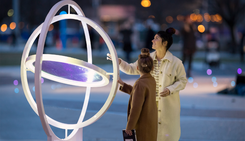 An adult and a child looking at an art installation.