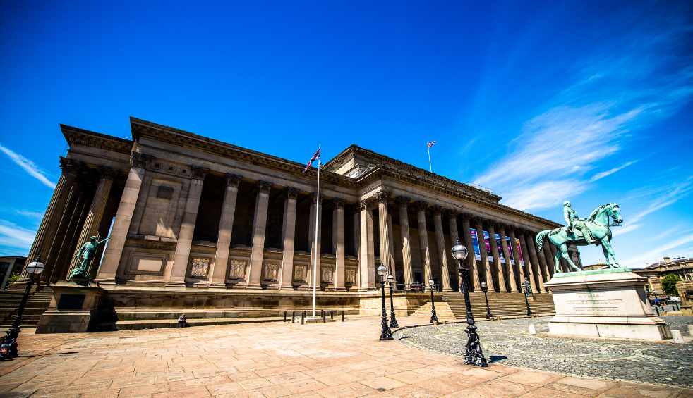 Outside of St George's Hall which is a large neoclassical building made of stone with pillars around the building.