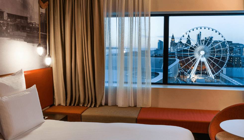 a room inside Pullman Liverpool with a view out the window of the Royal Albert Dock.