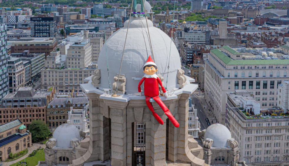 The giant elf on the shelf sat on top of the Liver Building
