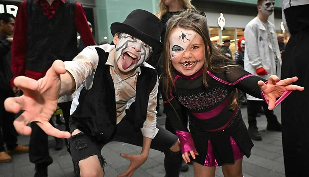 Two children in costumes posing for the camera
