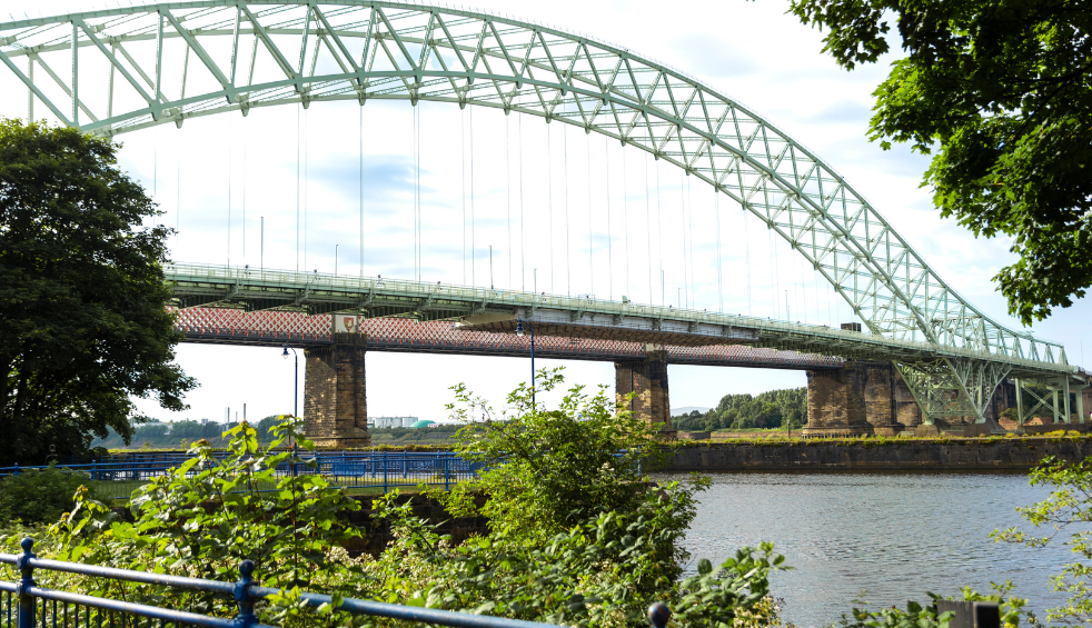 A pale green bridge crossing River Mersey