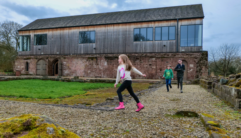 Three kids running round the ruins of Norton Priory.