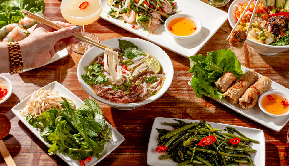 A table with plates of food from Pho.