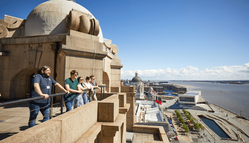 People stood looking over the edge of the royal liver building.