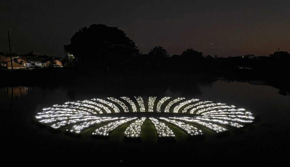 A light installation that looks like a circle of lights floating on water.