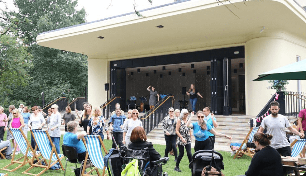 Outside of The Reader in Calderstones Park with people dancing outside.