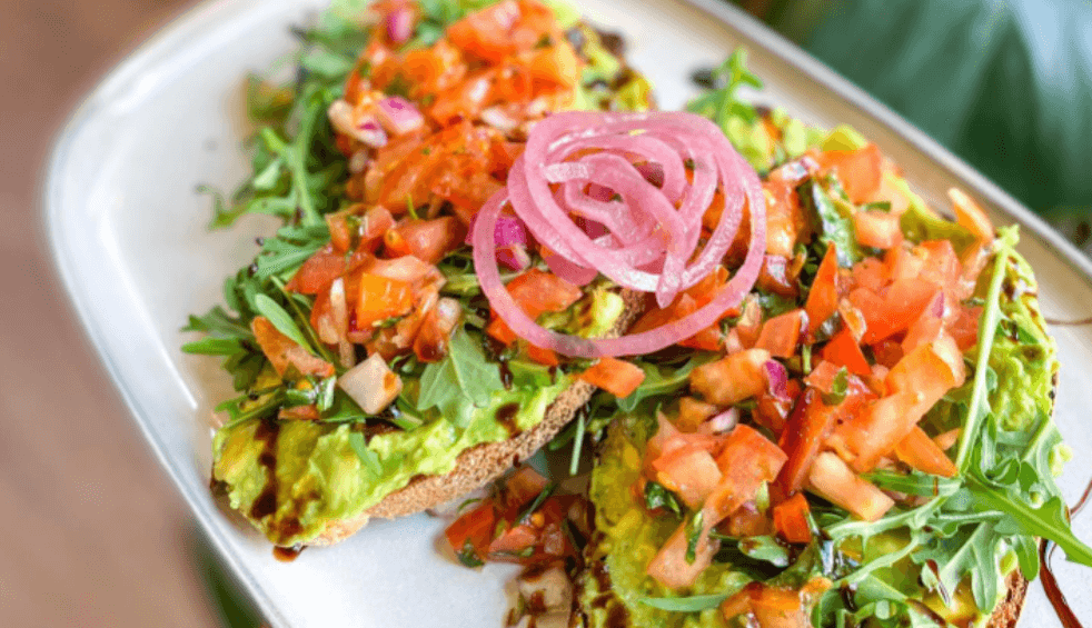 Avocado toast with rocket, tomatoes and red onion