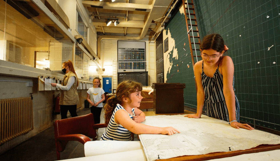 Two young children looking over a map in Western Approaches.