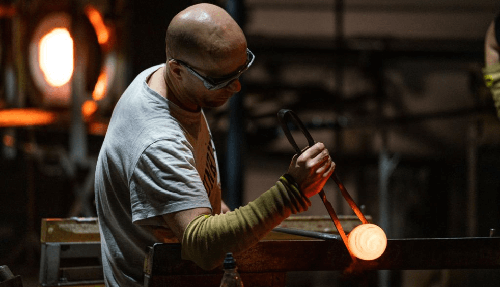 A person making glass in a workshop.