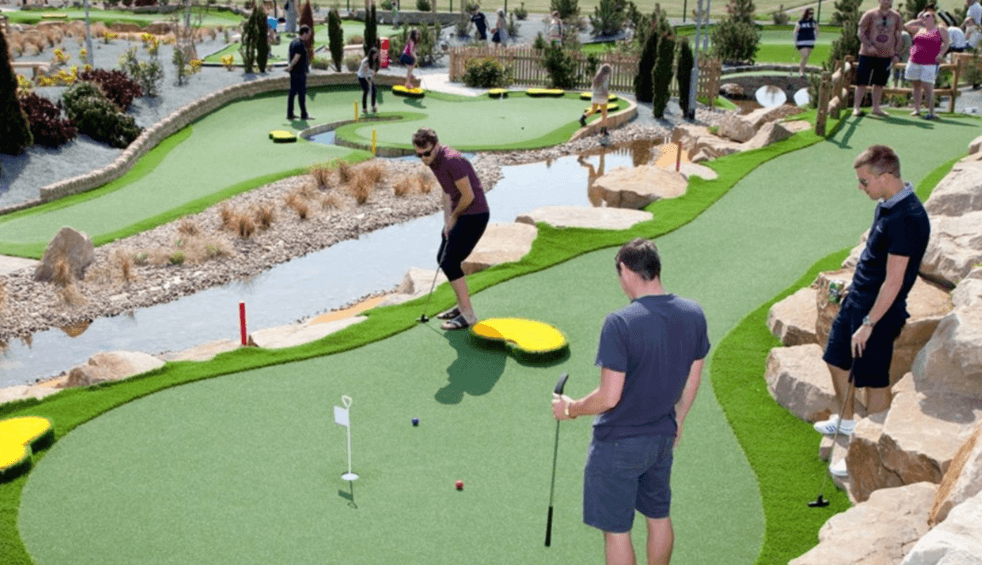 A group play a mini golf hole at Championship Adventure Golf.