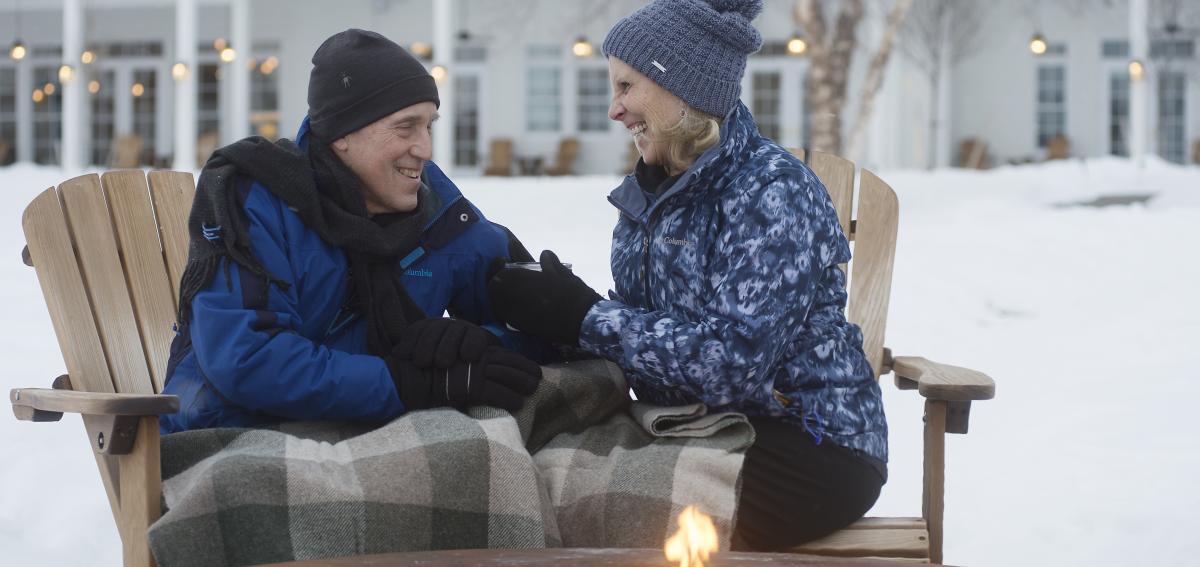 A couple enjoying the firepit by the water