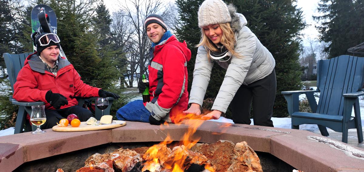 Guests enjoy après ski around a fire pit at the Belhurst Castle in Geneva, NY