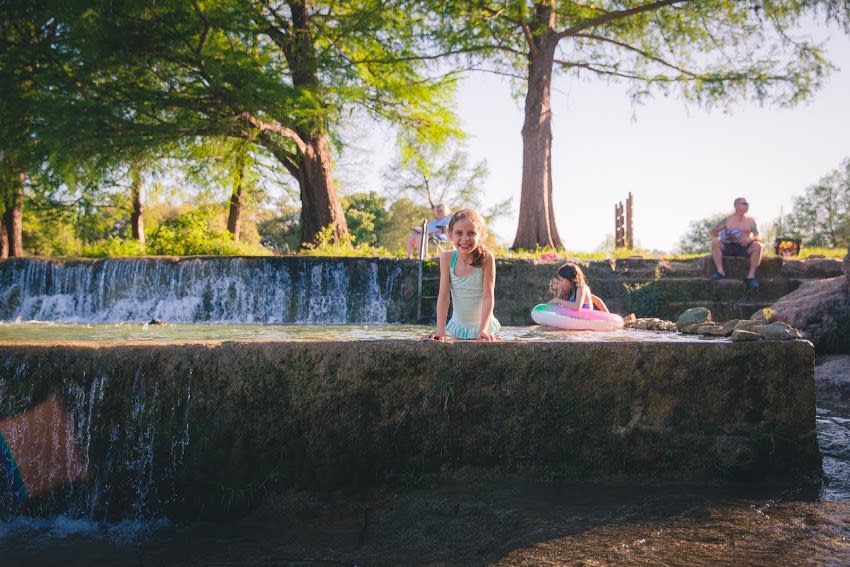 Two children swim in the river at Blanco State Park in Blanco Texas