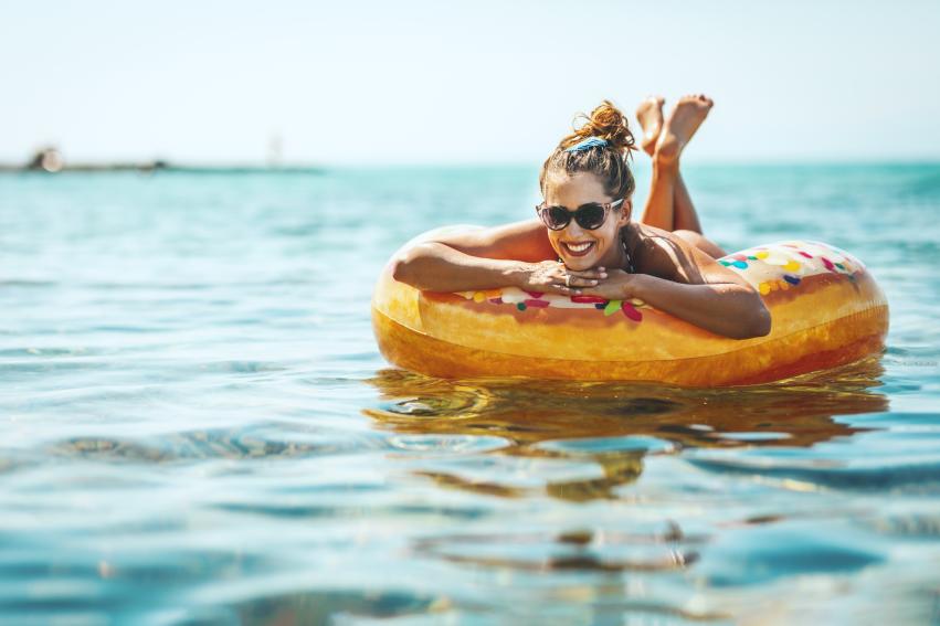 A woman laying in a tube floating in the Canandaigua Lake