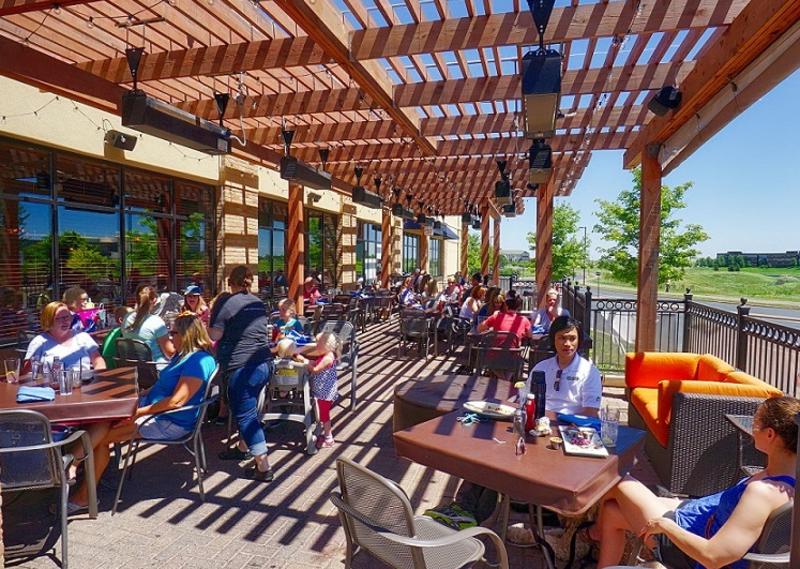 A wooden slatted veranda casts shadows over diners on 3 Squares Restaurant's patio