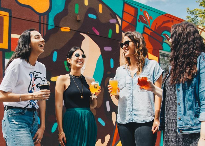 Group of girlfriends enjoying a glass of beer at a local craft brewery