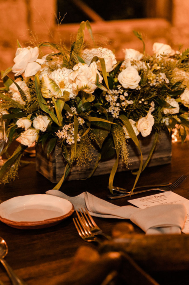 Table setting inside granite walled room with white floral centerpiece