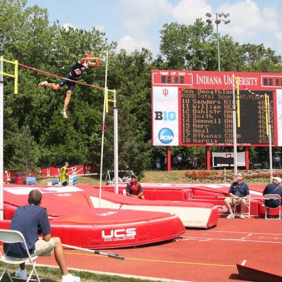 A male pole vaulter launching himself over the pole