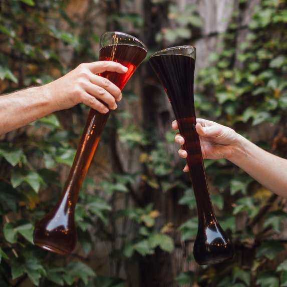 Two people cheers-ing yards of beer from The Irish Lion